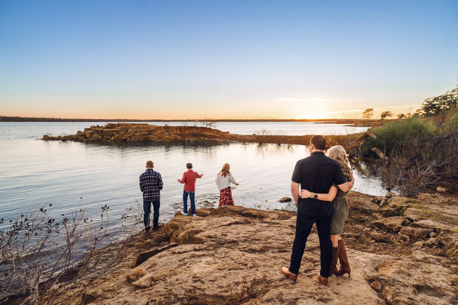 family watching sunset together during outdoor family photo session with Oklahoma City family photographer