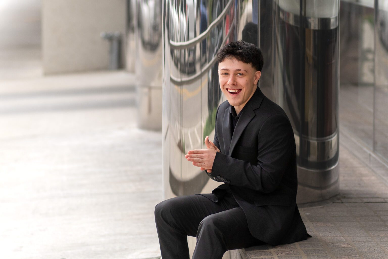 Senior Guy posing and sitting down in Urban Photo Session Oklahoma city for Missy Mayo Photography
